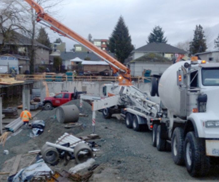 Concrete boom pump pouring at Maple Ridge condo development site